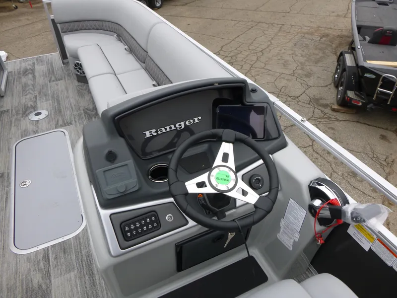 Slide: The Image of 2024 Ranger Reata 223C boat interior with steering console and seating. - 18