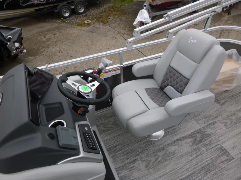 Slide: The Image of 2024 Ranger Reata 223C boat interior with gray captain's chair and steering console. - 19