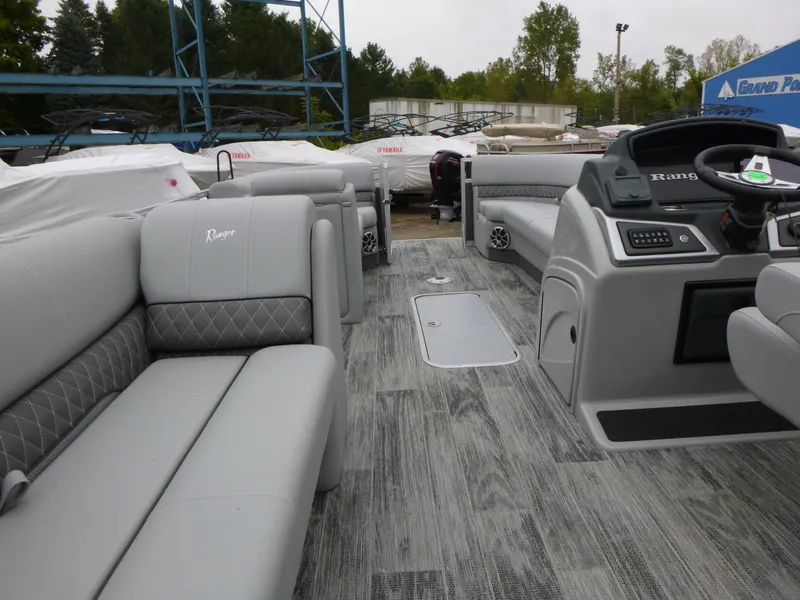 Slide: The Image of 2024 Ranger Reata 223C pontoon boat interior with gray seating and modern dashboard. - 25
