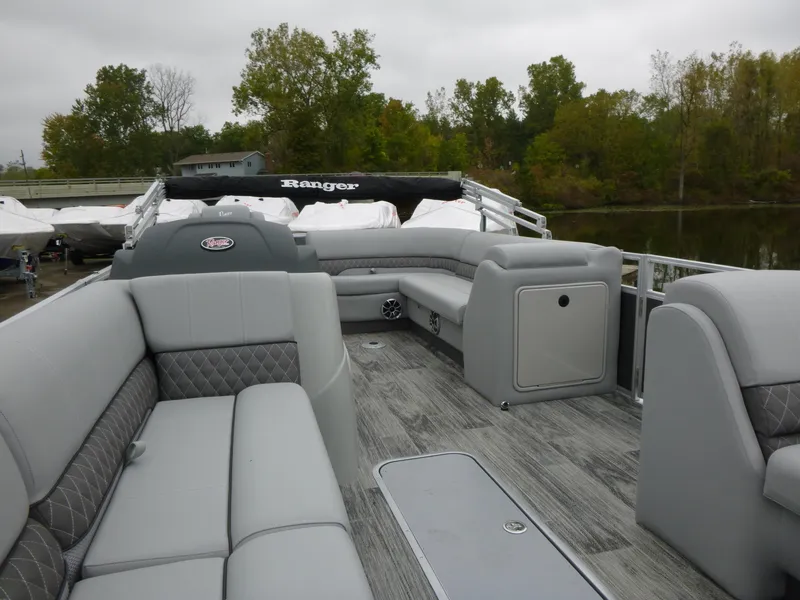 Slide: The Image of 2024 Ranger Reata 223C pontoon boat with gray seating and wood-style flooring. - 26