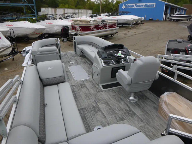 Slide: The Image of 2024 Ranger Reata 223C pontoon boat with spacious seating and modern helm. - 28