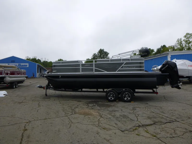 Slide: The Image of 2024 Ranger Reata 223C pontoon boat on trailer in outdoor lot. - 5