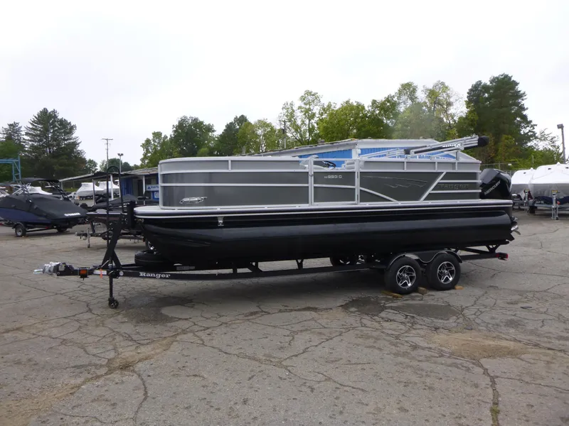 Slide: The Image of 2024 Ranger Reata 223C pontoon boat on trailer in outdoor setting. - 6