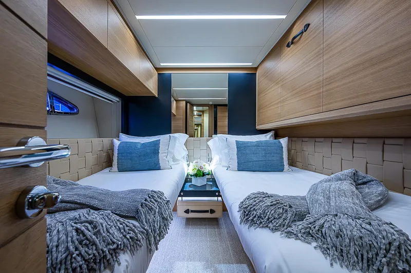 Slide: The Image of Luxurious twin cabin interior on 2014 Pershing 92 yacht, featuring modern design and cozy bedding. - 25