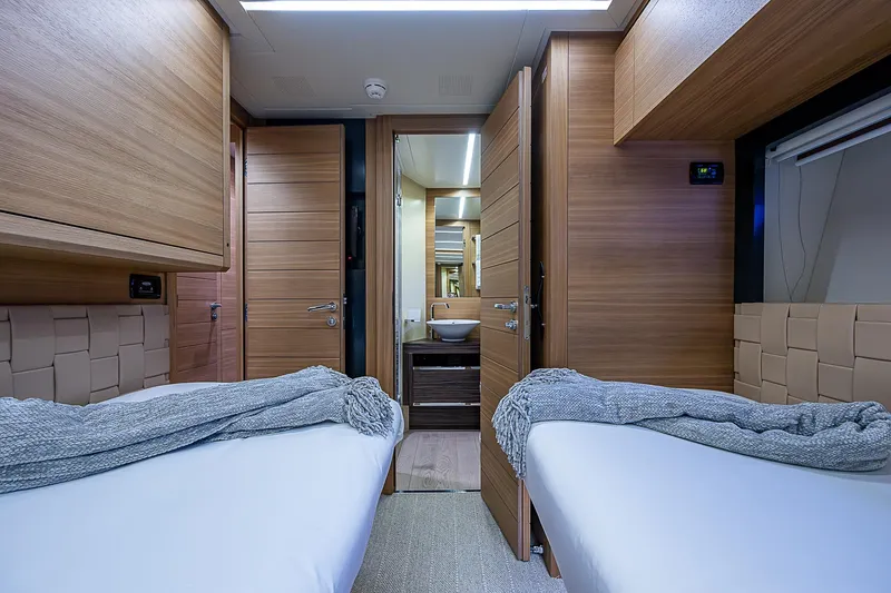 Slide: The Image of Luxurious 2014 Pershing 92 yacht cabin with twin beds and modern wood finish. - 27