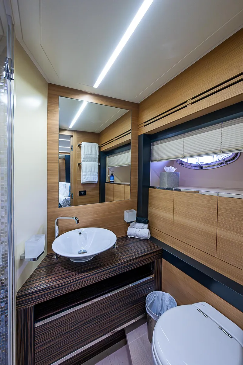 Slide: The Image of Luxurious bathroom in 2014 Pershing 92 yacht with modern fixtures and wood accents. - 28