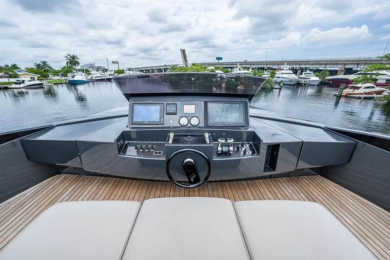Slide: The Image of Helm of 2014 Pershing 92 yacht with marina view, featuring modern controls and navigation equipment. - 35