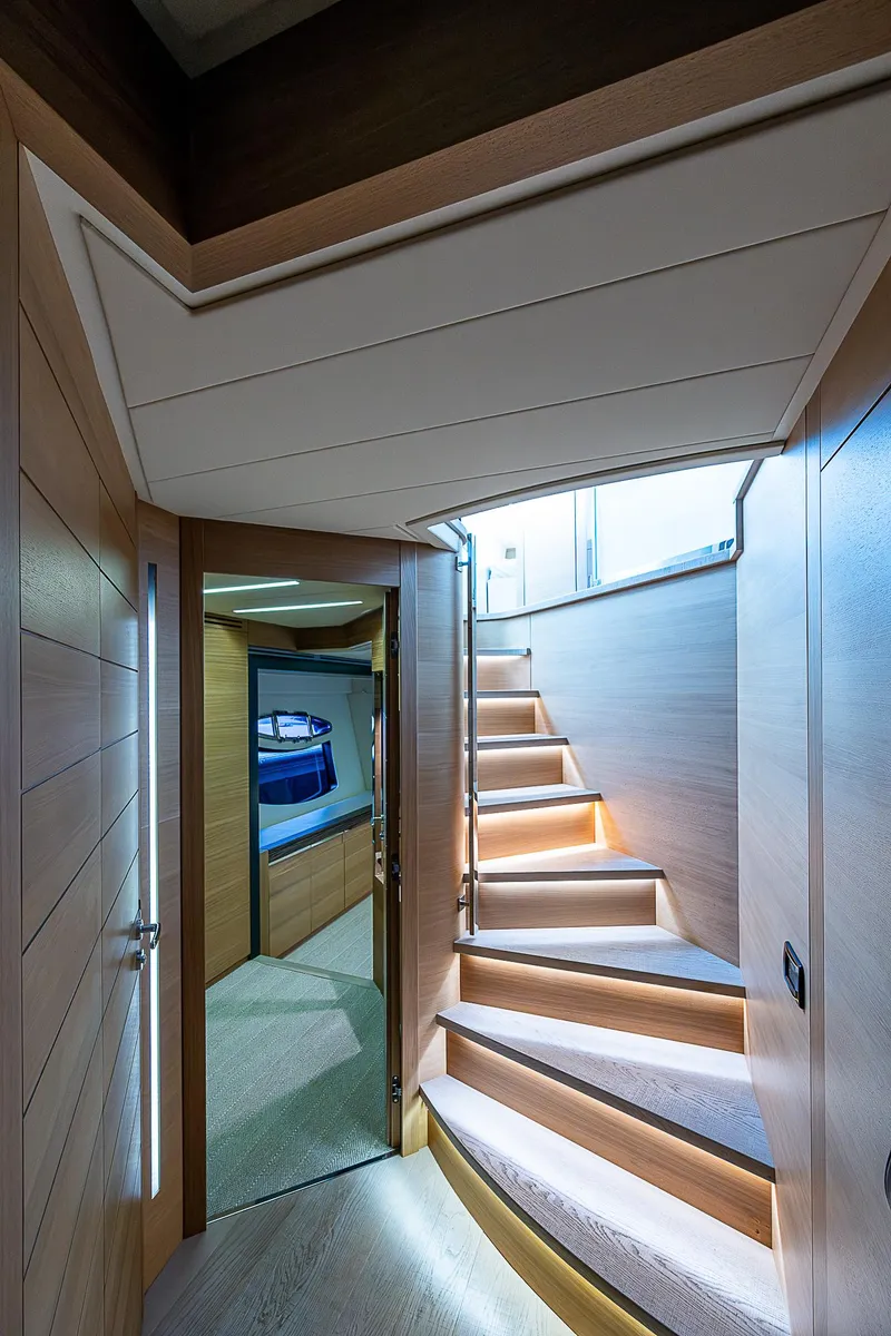 Slide: The Image of Interior of 2014 Pershing 92 yacht with modern wooden staircase and sleek design. - 8