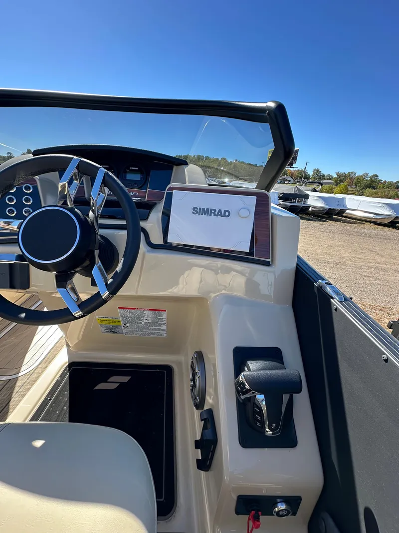 Slide: The Image of 2024 Starcraft RX23QDC 3.0 boat dashboard with steering wheel and Simrad display. - 11