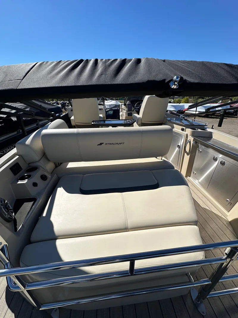 Slide: The Image of 2024 Starcraft RX23QDC 3.0 boat with beige seating and canopy, docked under clear blue sky. - 17