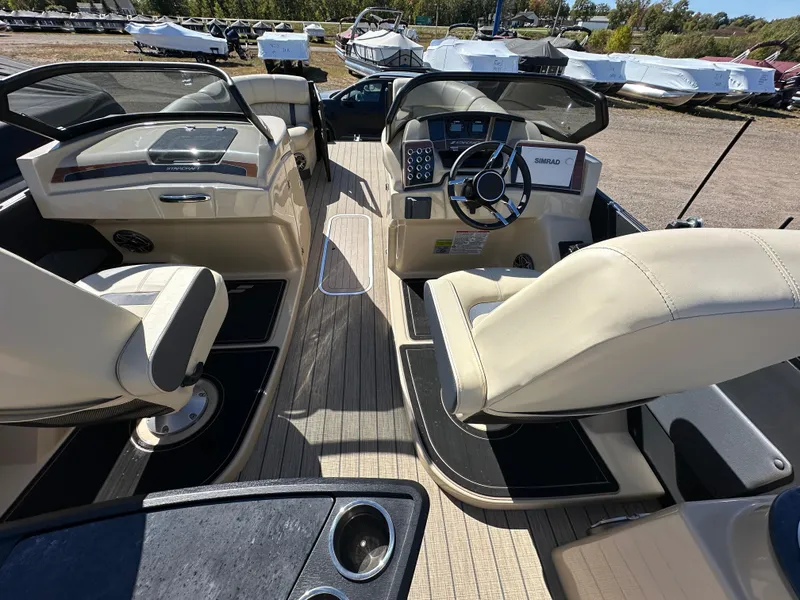 Slide: The Image of 2024 Starcraft RX23QDC 3.0 boat interior with beige seating and modern dashboard. - 22