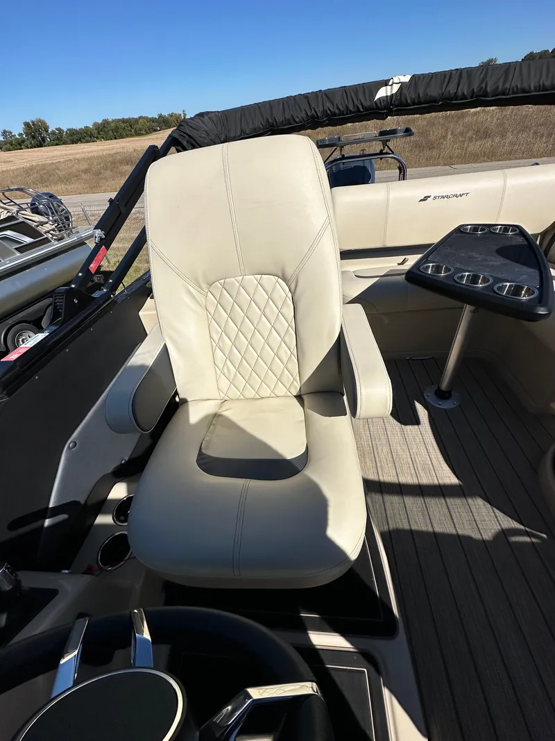 Slide: The Image of 2024 Starcraft RX23QDC 3.0 boat interior with beige captain's chair and steering wheel. - 8