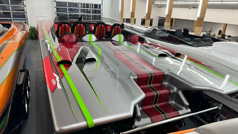 Slide: The Image of 2021 Skater 438 powerboat with vibrant red and green accents in a showroom. - 17