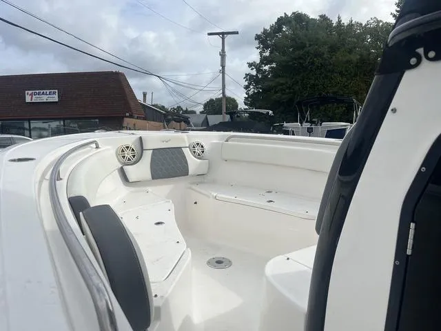 Slide: The Image of 2020 Tidewater 232 LXF boat interior with seating and speakers, displayed at a dealership. - 9