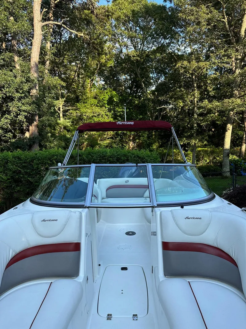 Slide: The Image of 2016 Hurricane SD2200 O/B boat with red accents, surrounded by lush greenery. - 10