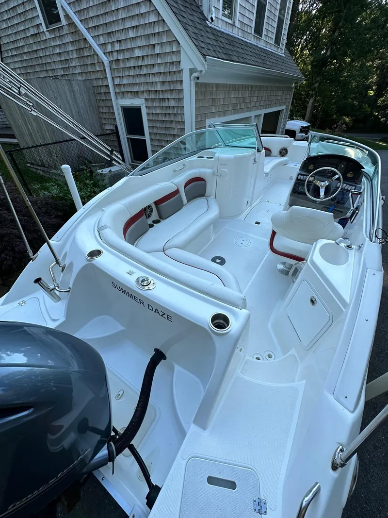 Slide: The Image of 2016 Hurricane SD2200 O/B boat with white interior, parked near a house. - 8
