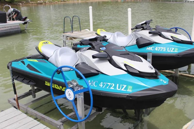 The Image of 2024 Sea-Doo GTI 170 jet skis docked on a serene lake. - 1