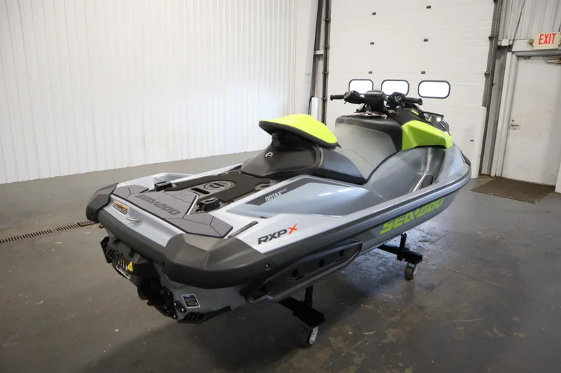 Slide: The Image of 2025 Sea-Doo RXP-X™ 325 iBR in Ice Metal and Manta Green, displayed indoors. - 3