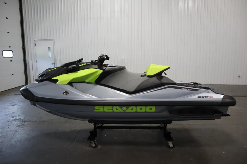 Slide: The Image of 2025 Sea-Doo RXP-X 325 iBR in Ice Metal and Manta Green, displayed indoors. - 5