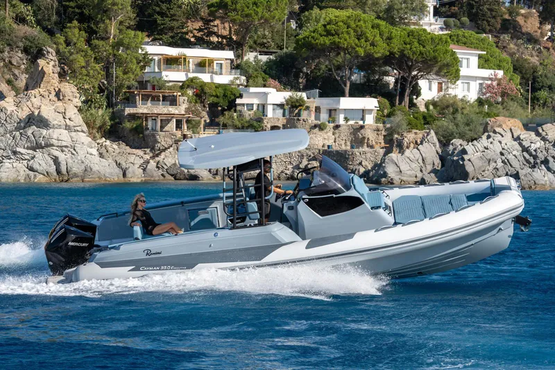 Slide: The Image of 2025 Ranieri Cayman 33 Executive cruising on blue waters near coastal villas. - 1