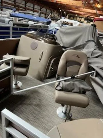 Slide: The Image of 2022 Bennington 168 SF boat interior with seats and steering, stored indoors. - 13