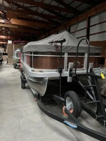 Slide: The Image of 2022 Bennington 168 SF boat motor on trailer, parked on pavement near grass. - 4