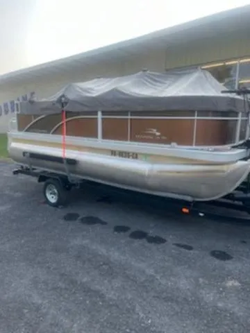 Slide: The Image of 2022 Bennington 168 SF pontoon boat on trailer, covered and parked outdoors. - 7