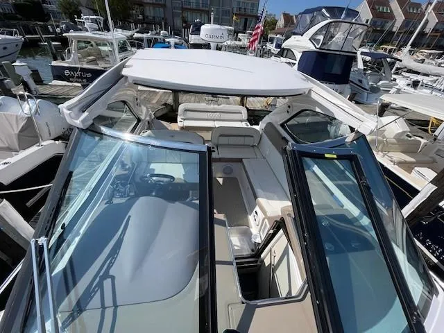 Slide: The Image of 2018 Regal 35 Sport Coupe boat docked at marina, featuring open cockpit and sleek design. - 15