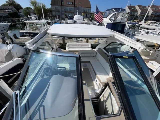 Slide: The Image of 2018 Regal 35 Sport Coupe boat docked in a marina, featuring spacious seating and modern design. - 17