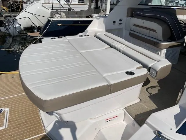 Slide: The Image of 2018 Regal 35 Sport Coupe boat with cushioned seating and cup holders on deck. - 31