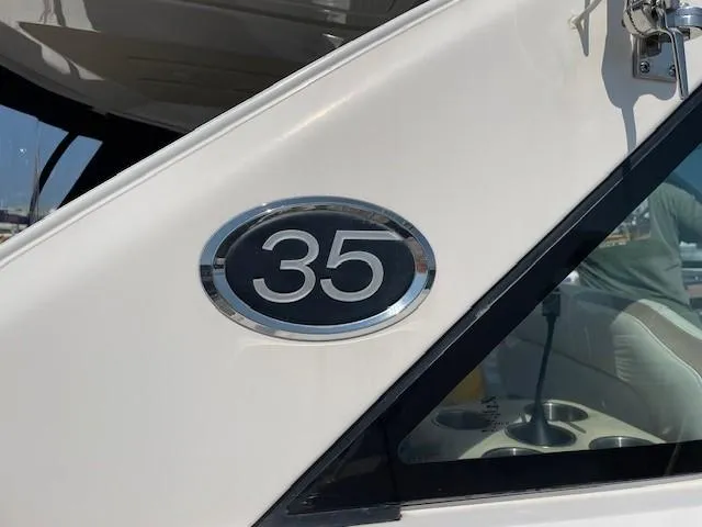 Slide: The Image of 2018 Regal 35 Sport Coupe boat emblem on white exterior. - 36
