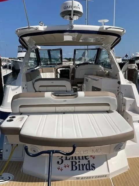 Slide: The Image of 2018 Regal 35 Sport Coupe boat with spacious seating and Garmin equipment at a marina. - 4