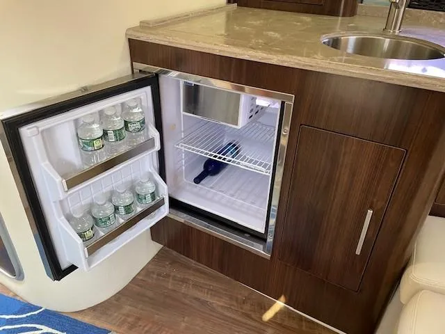 Slide: The Image of Compact fridge in 2018 Regal 35 Sport Coupe, stocked with water bottles, next to a sink. - 44