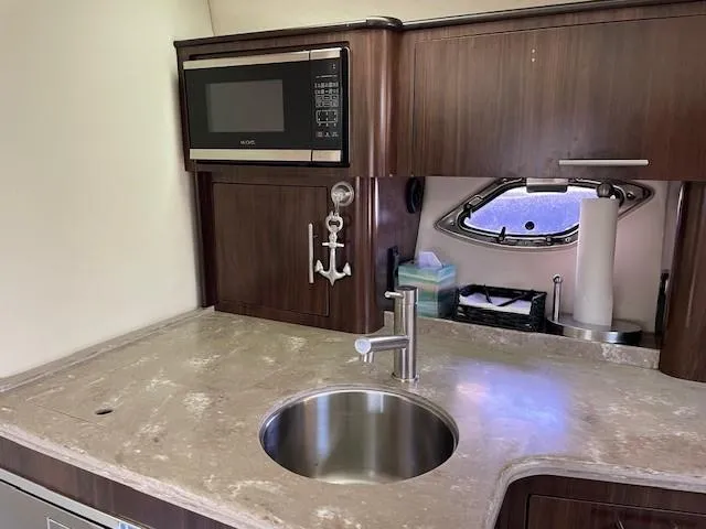 Slide: The Image of Modern kitchen area in a 2018 Regal 35 Sport Coupe yacht with sink and microwave. - 45