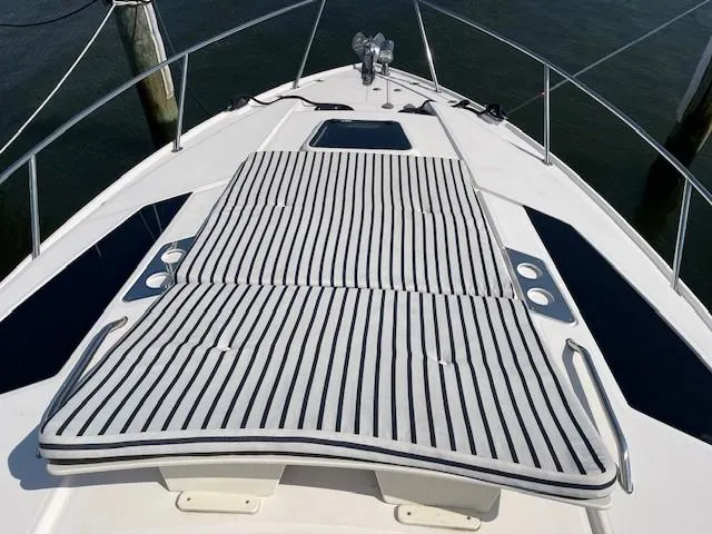 Slide: The Image of 2018 Regal 35 Sport Coupe boat with striped sunbathing cushions on deck. - 7
