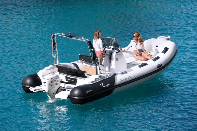 Slide: The Image of 2025 Ranieri CAYMAN 19 Sport boat on clear blue water with two people onboard. - 3