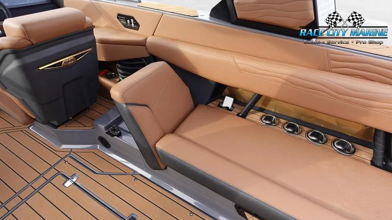Slide: The Image of 2025 Nautique Super Air Nautique G25 interior with tan leather seating and wood flooring. - 27