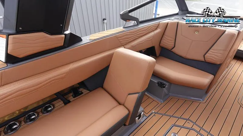 Slide: The Image of 2025 Nautique Super Air Nautique G25 interior with tan leather seating and wood flooring. - 28
