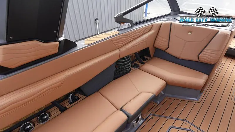 Slide: The Image of 2025 Nautique Super Air Nautique G25 interior with tan leather seating and wood flooring. - 29