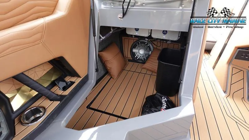 Slide: The Image of 2025 Nautique Super Air Nautique G25 interior with tan seating and wood-style flooring. - 30