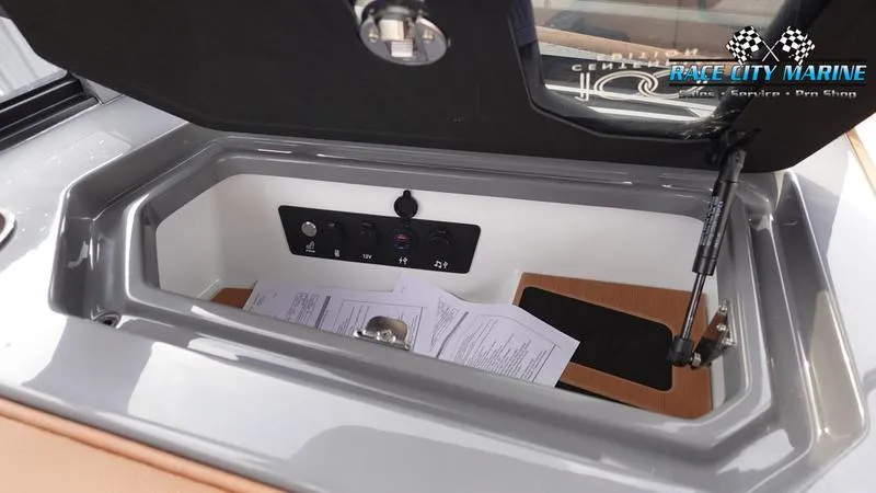 Slide: The Image of 2025 Nautique Super Air Nautique G25 storage compartment with control panel and documents. - 32