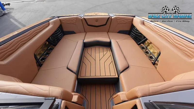 Slide: The Image of 2025 Nautique Super Air Nautique G25 boat interior with tan seating and wood accents. - 46