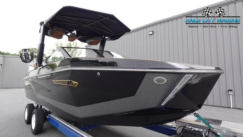Slide: The Image of 2025 Nautique Super Air Nautique G25 boat on trailer, sleek black design, Race City Marine logo. - 5