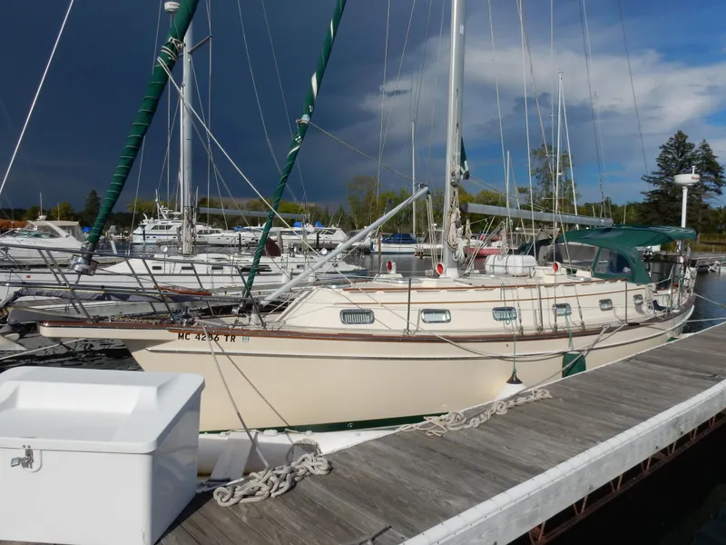 Slide: The Image of 1997 Island Packet 40 sailboat docked at marina under cloudy sky. - 1