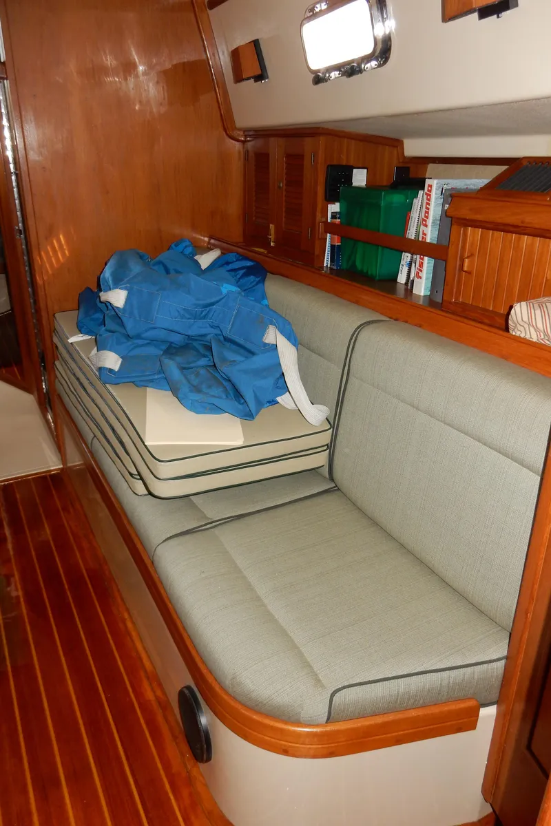 Slide: The Image of Interior of 1997 Island Packet 40 sailboat with cushioned seating and wooden flooring. - 10