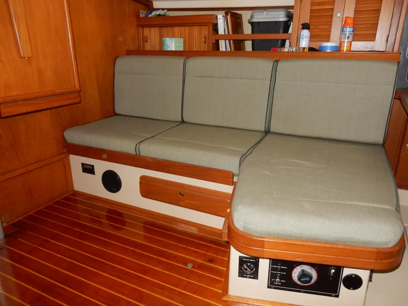 Slide: The Image of Interior of 1997 Island Packet 40 sailboat with cushioned seating and wooden flooring. - 12