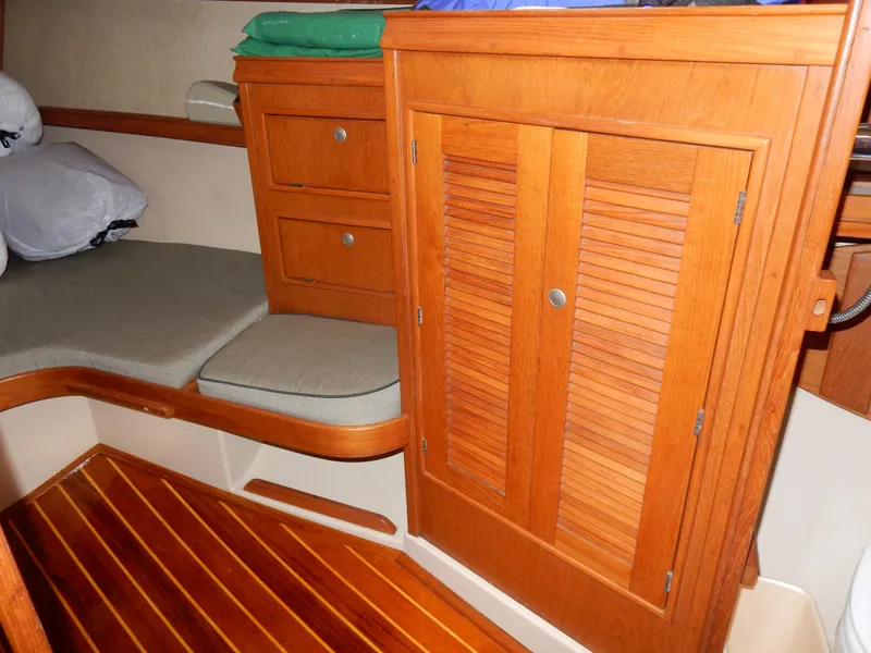 Slide: The Image of Interior of 1997 Island Packet 40 sailboat with wooden cabinetry and seating area. - 13