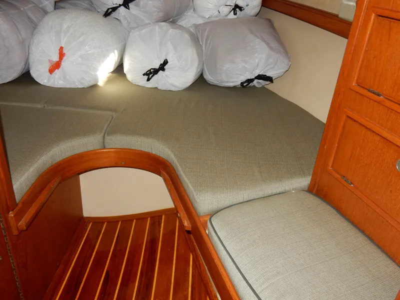 Slide: The Image of Cozy cabin interior of 1997 Island Packet 40 sailboat with cushioned seating and storage bags. - 15