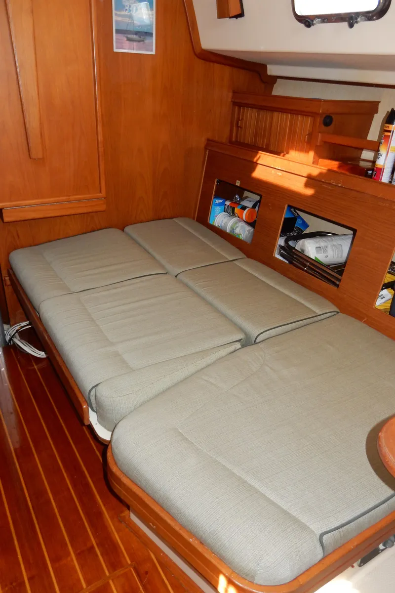 Slide: The Image of 1997 Island Packet 40 interior with a cozy, convertible bed and wooden accents. - 16