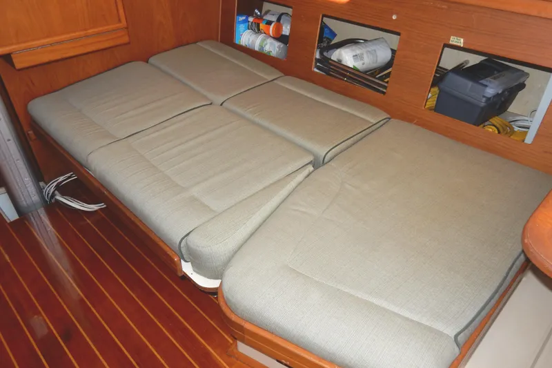 Slide: The Image of Interior view of 1997 Island Packet 40 sailboat with cushioned seating and wooden flooring. - 17